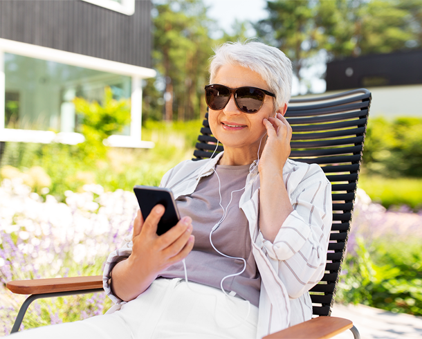woman listening to podcast in garden.png